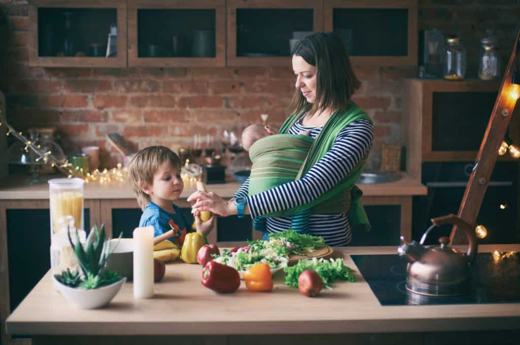 Mom and two young children preparing vegetables.