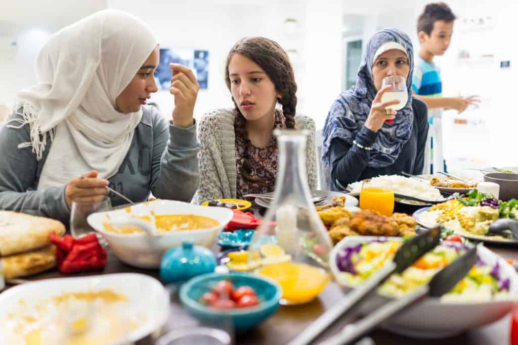 Family and friends gathering together at home for eating dinner