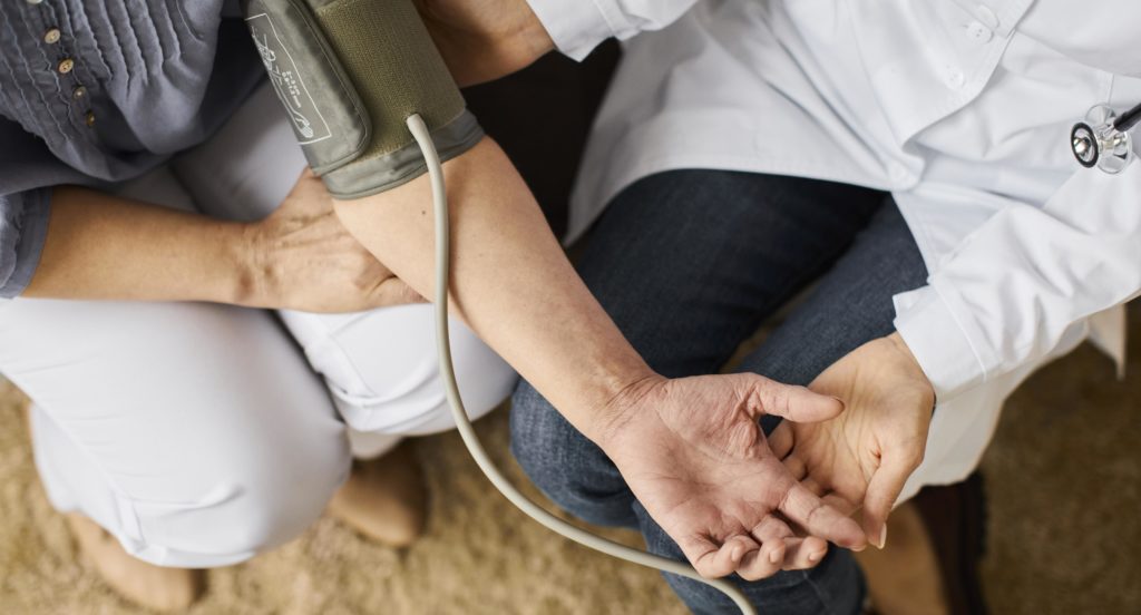 doctor checking patient's blood pressure