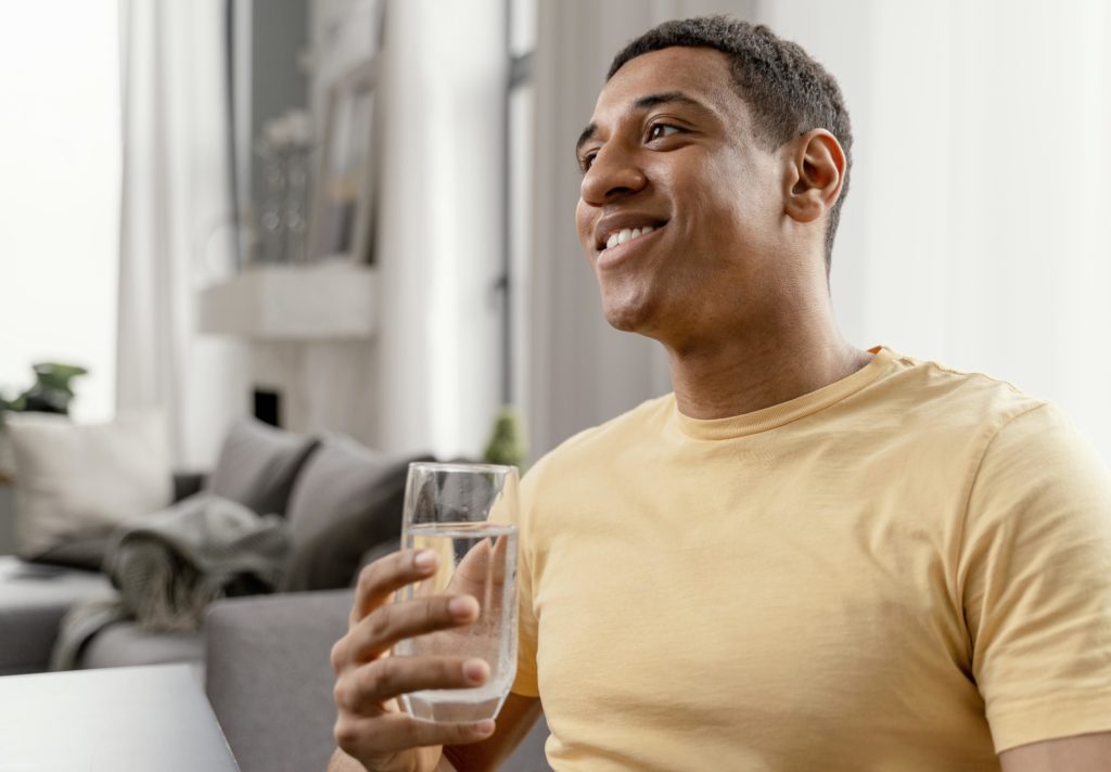 Man at home drinking glass of water